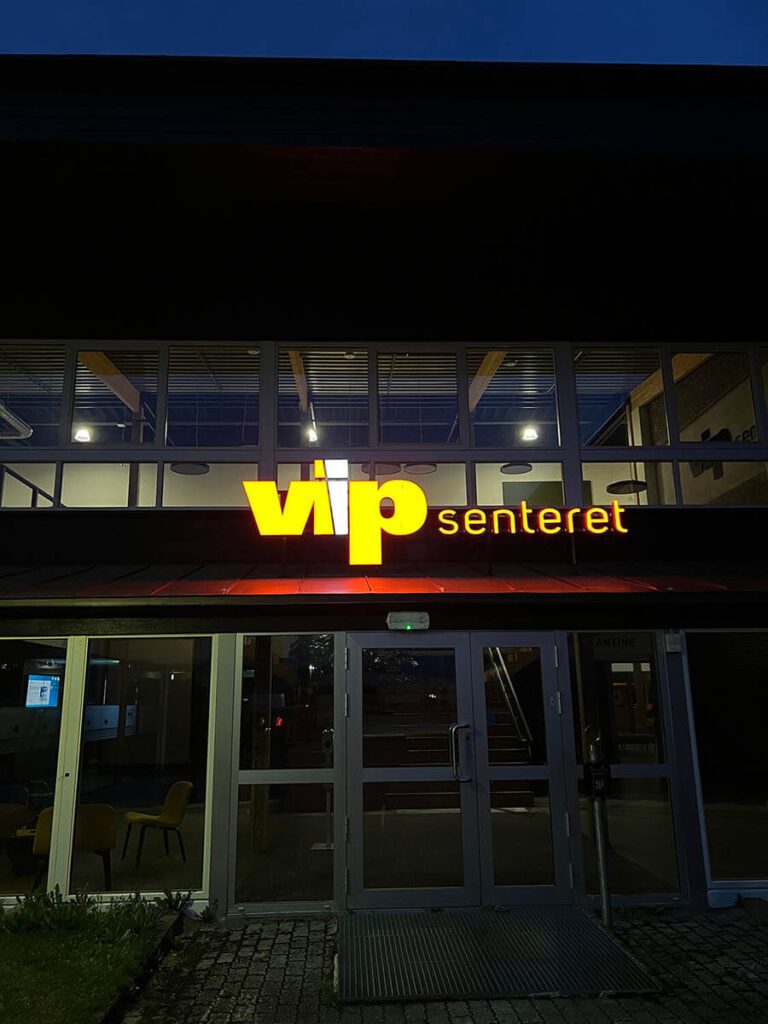 Utendørs lysskilt hos VIP-senteret i mørket.