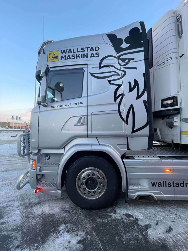 Sølvfarget lastebil med logo for Wallstad Maskin AS.
