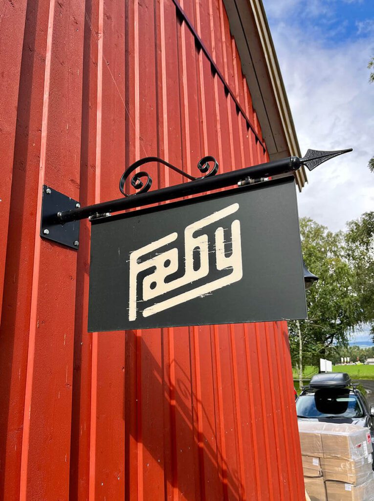 Svart utendørs skilt med logoen til Fæby.