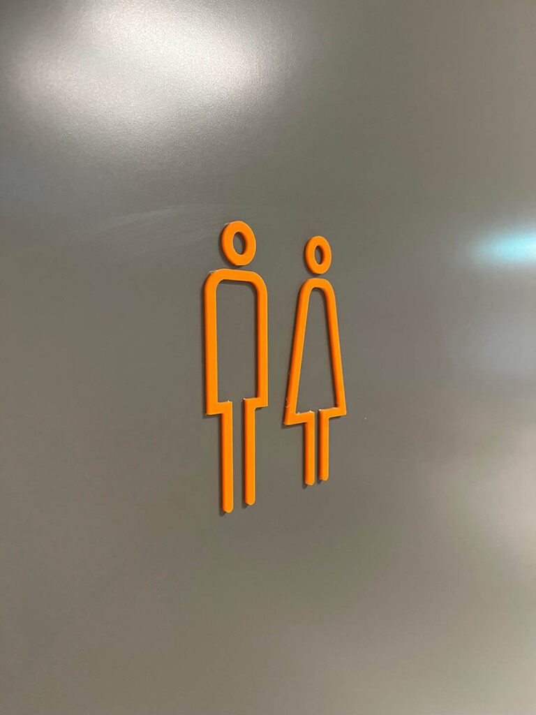 Oransje skilt for toalett.