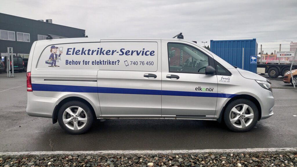 Sølvfarget bil med reklame for Elektriker-Service.
