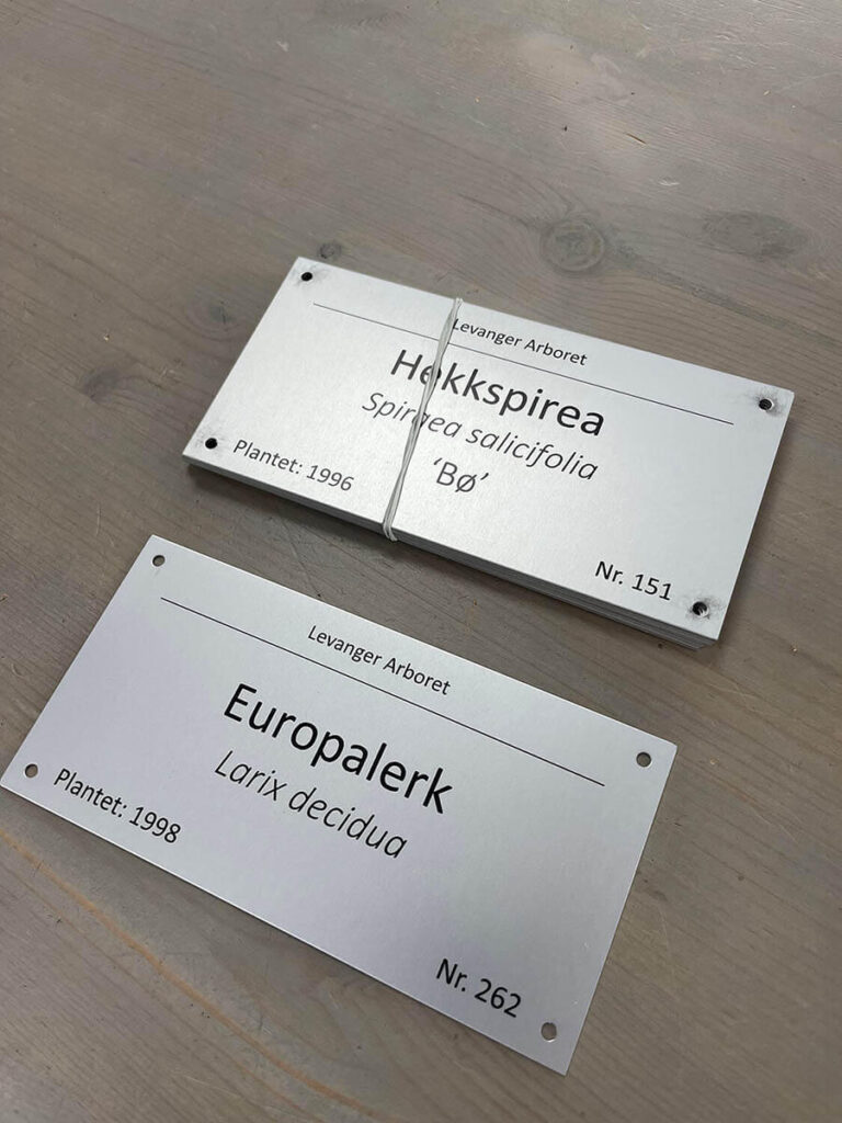 Små informasjonsskilt for Levanger Arboret.