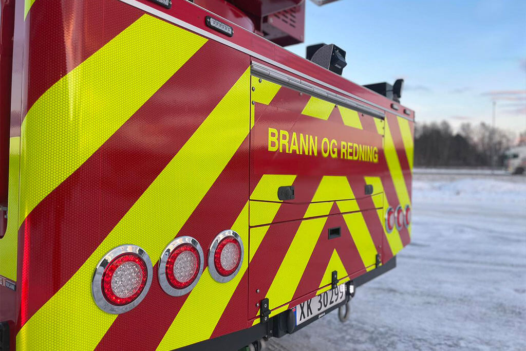 Brannbil dekorert med gule refleksstriper hos GV Reklame.